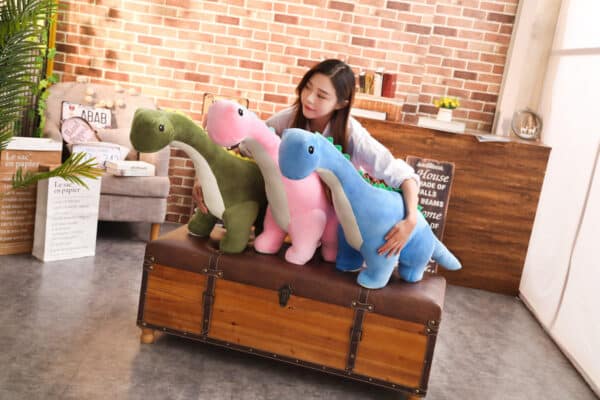 girl hugging 3 Dinosaur Stuffed Animal